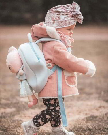 Dziewczynka z plecakiem na plecach z boku