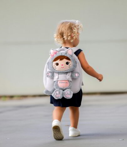 Dziewczynka z pluszowym plecakiem i lalką Metoo Kotką z imieniem